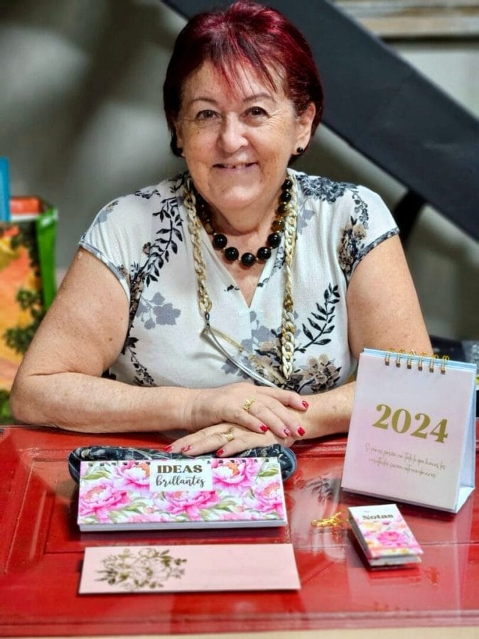 Participante con la agenda que encuadernó en el taller